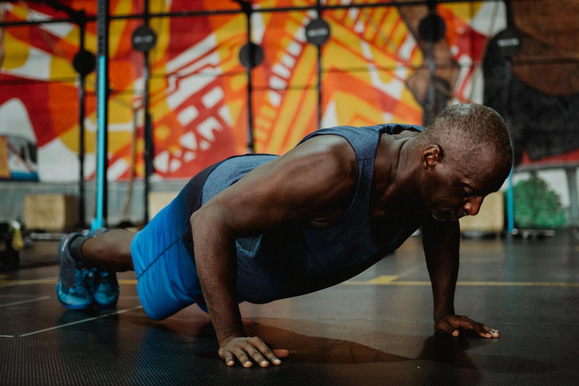 Man performing a bodyweight exercise in a minimalist gym setting.